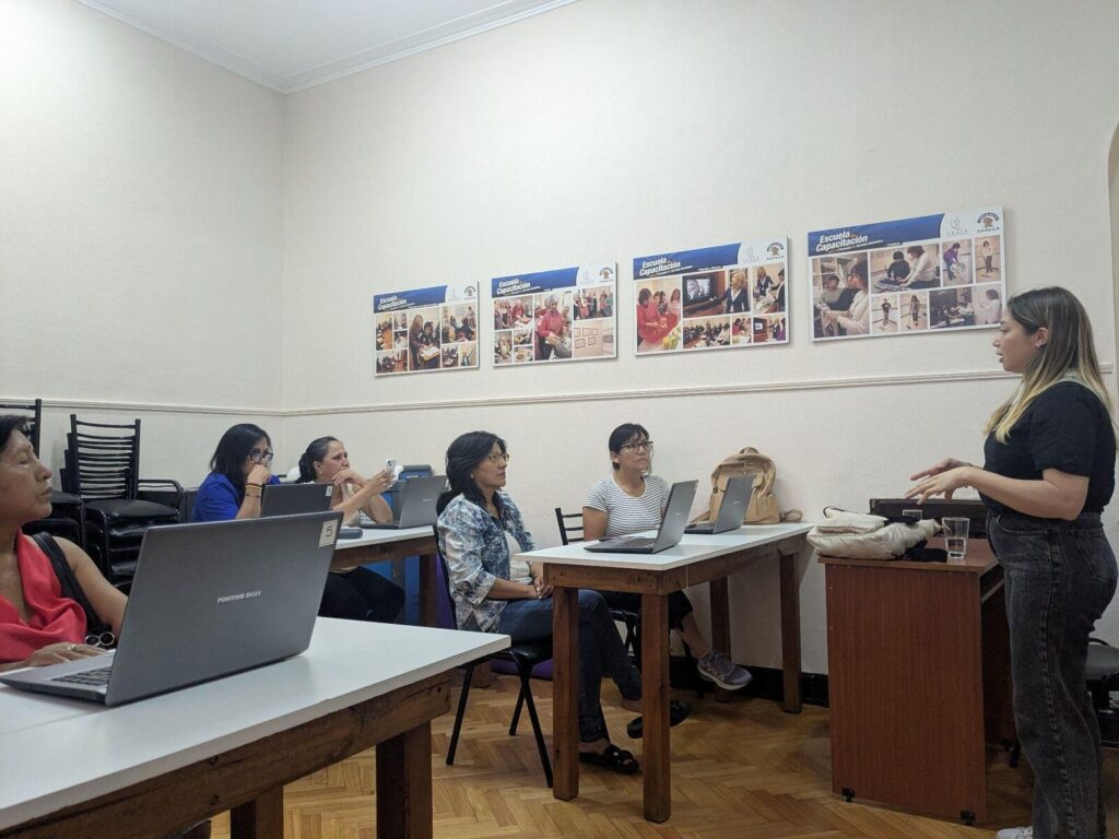 People working on laptops at desks in a classroom during a user-testing session